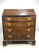 Antique bureau with fall front revealing pigeon holes and drawers, with brass fittings