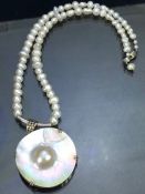 Seed Pearl necklace with Silver clasp and a Silver mounted mother of pearl shell with central