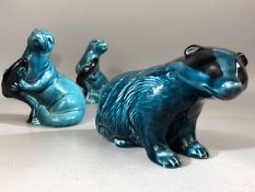 Group of Poole Pottery animals to include two otters with fish and a badger (3)