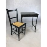 Black painted small table with turned legs, on castors, along with a black painted, cane seated