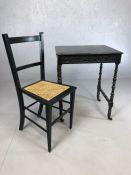 Black painted small table with turned legs, on castors, along with a black painted, cane seated