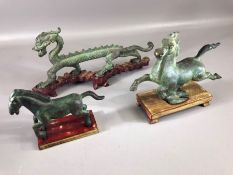 Three Chinese Bronze sculptures including Flying Horse of Gansu each on wooden plinths, two horses