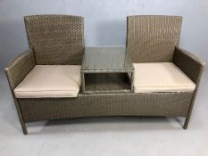 Contemporary rattan garden two seater love seat with central glass-topped table and cushions