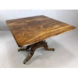 Antique Pembroke table with hidden drawers to either end on four splayed feet and brass castors