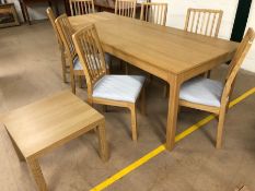 Large extendable light wood IKEA dining table with eight matching upholstered dining chairs.
