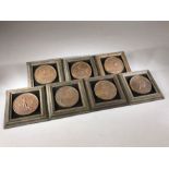 Collection of seven framed medallions, each approx 6.5cm in diameter, depicting military scenes,