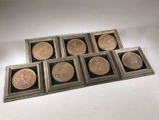 Collection of seven framed medallions, each approx 6.5cm in diameter, depicting military scenes,