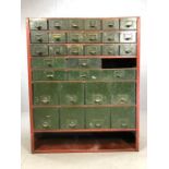 Industrial metal filing cabinet of multiple graduated drawers, with shelf under, in red metal