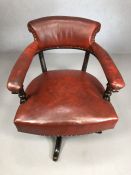 Antique red leather captain's chair on swivel base with stud detailing