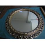 Circular wall mirror in ornate gilt frame