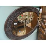 Most ornate oval bevel edged wall mirror in carved oak frame