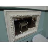 Rectangular wall mirror in ornate carved white painted frame within embossed garland decoration