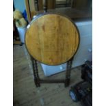 Oak circular topped table on folding twist stemmed base (23" diam.