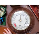 Steel dialled aneroid barometer in circular carved oak case