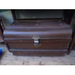 Battened brown painted tin travelling trunk with brass lock