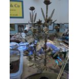 Pair of ornate brass candleholders inset ears of wheat and bunches of grapes etc.