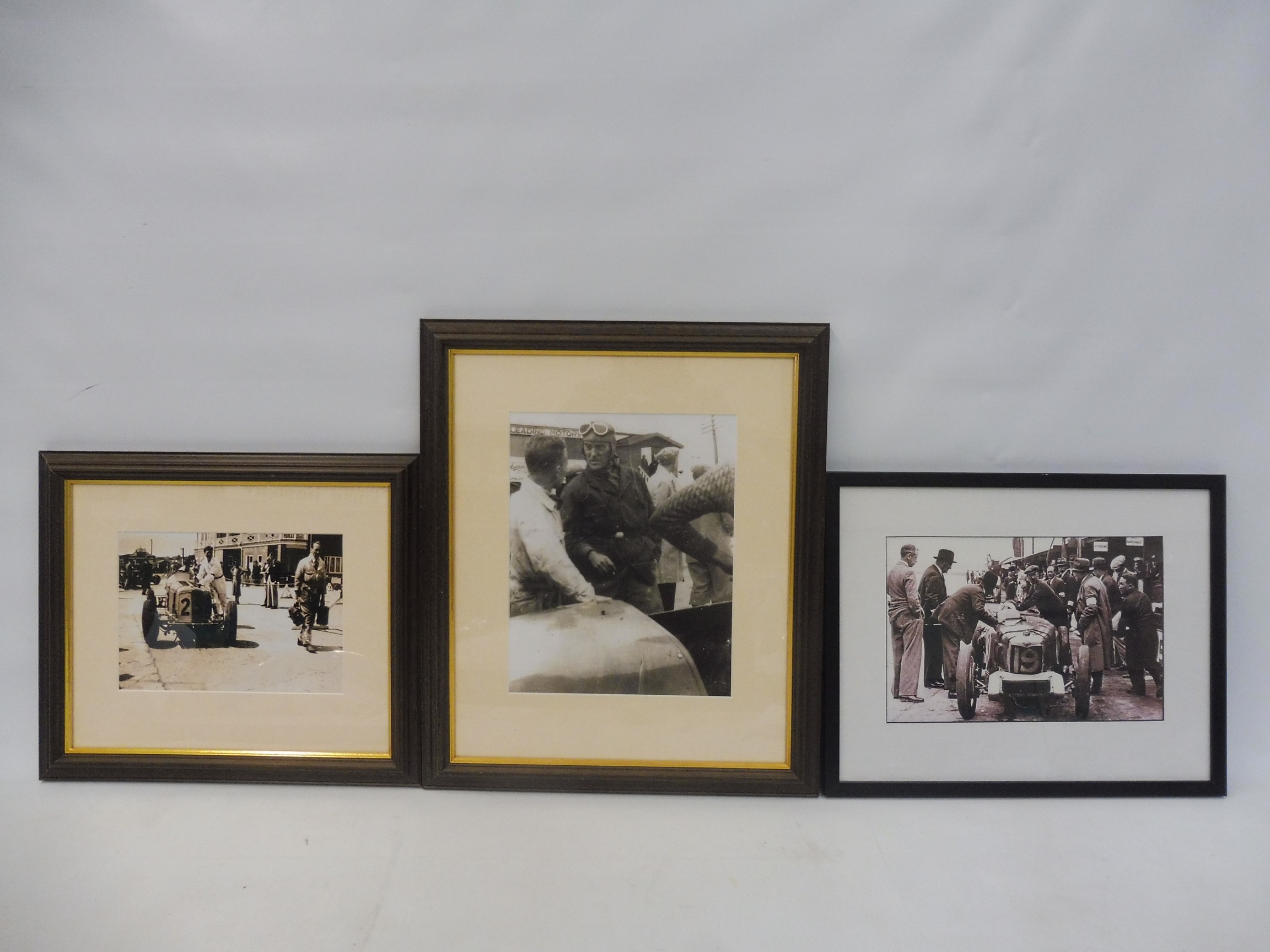 Three framed and glazed photographs of cars and their drivers in the pits/paddock at Brooklands,