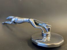 A Ford Lincoln greyhound car mascot, chrome plated finish, mounted on a large radiator cap.