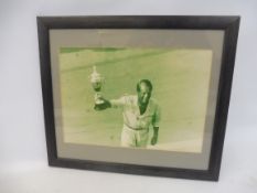 A framed and glazed photograph by Bernard Cahier of Peter Collins with trophy, 14 1/4 x 12 1/4".