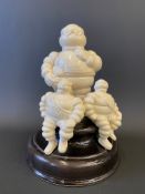 A contemporary glazed pottery desktop model of three Michelin Mr. Bibendum figures.