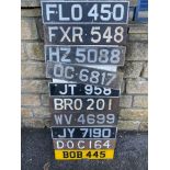 A display board covered in old number plates.