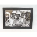 A framed and glazed driver's briefing photograph, depicting Bruce mcLaren, Jim Hall, Trevor