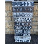 A display board covered in old number plates.