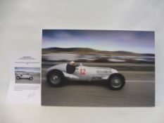 A photograph on stretched canvas of Hermann Lang in a 1937 Mercedes Benz W125, with certificate of