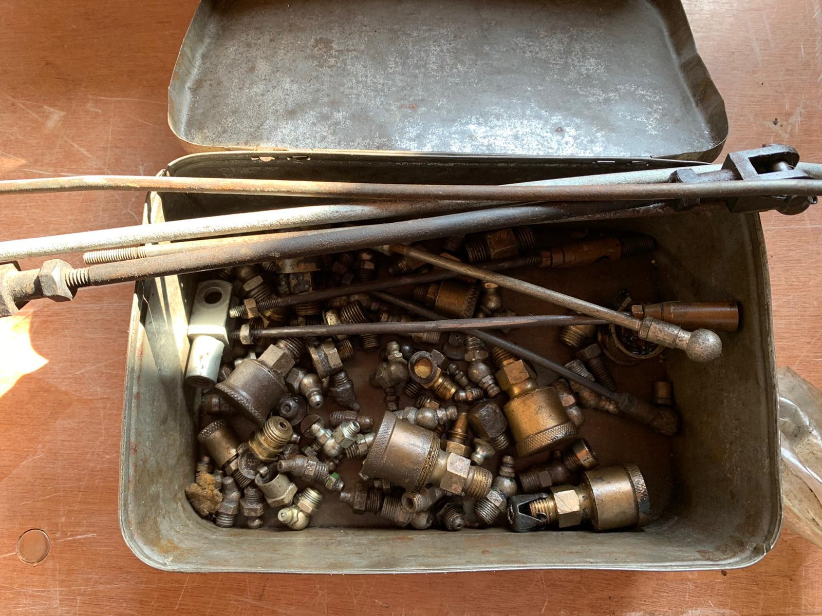 A small tin of early grease nipples and caps, linkages etc.