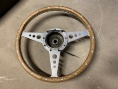 A Moto Lita wooden rimmed steering wheel and central hub.