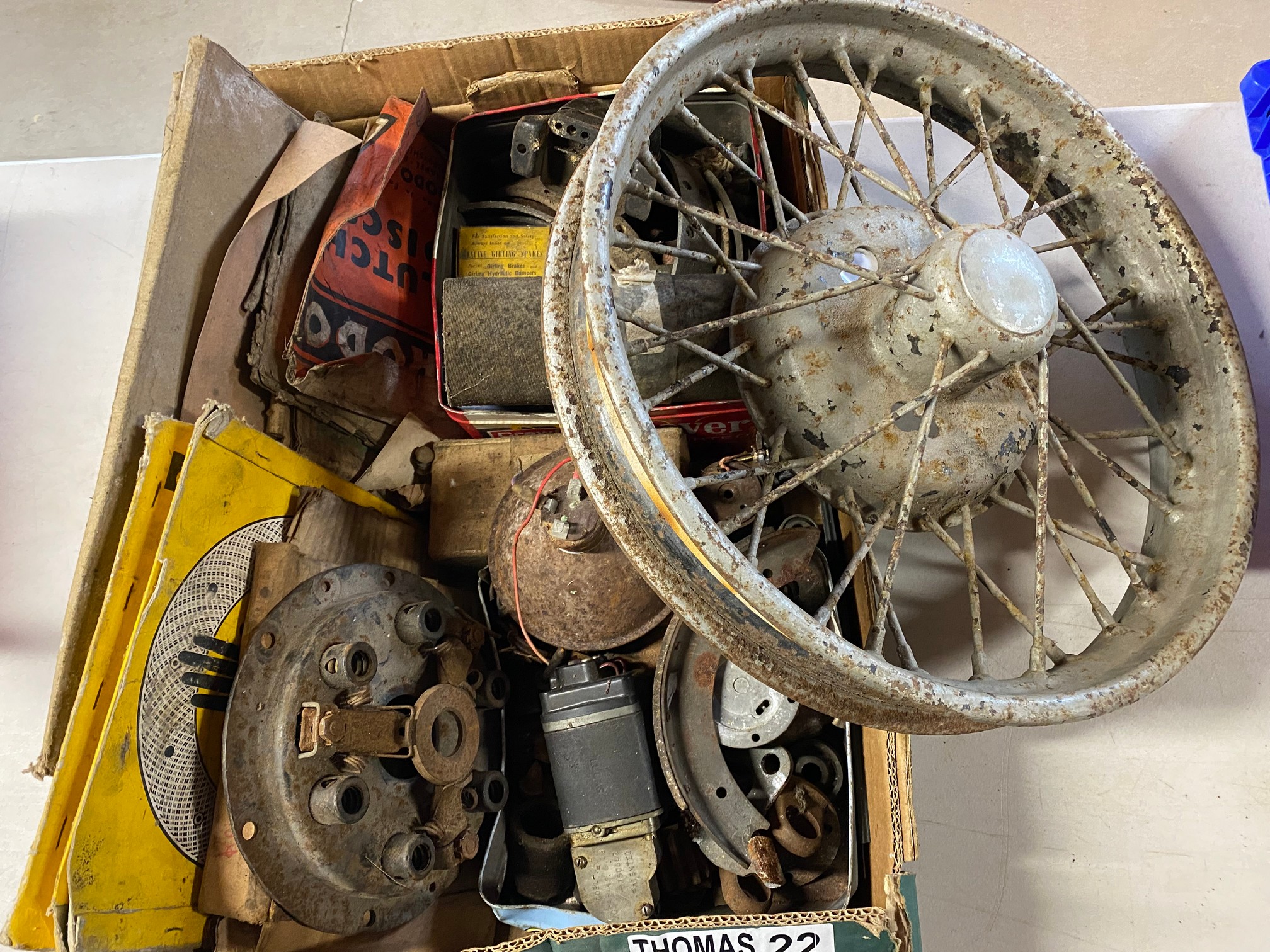 A box of Austin parts plus an Austin 7 wheel.