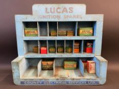 A Lucas Ignition Spares counter top dispensing rack with numerous sections with assorted original