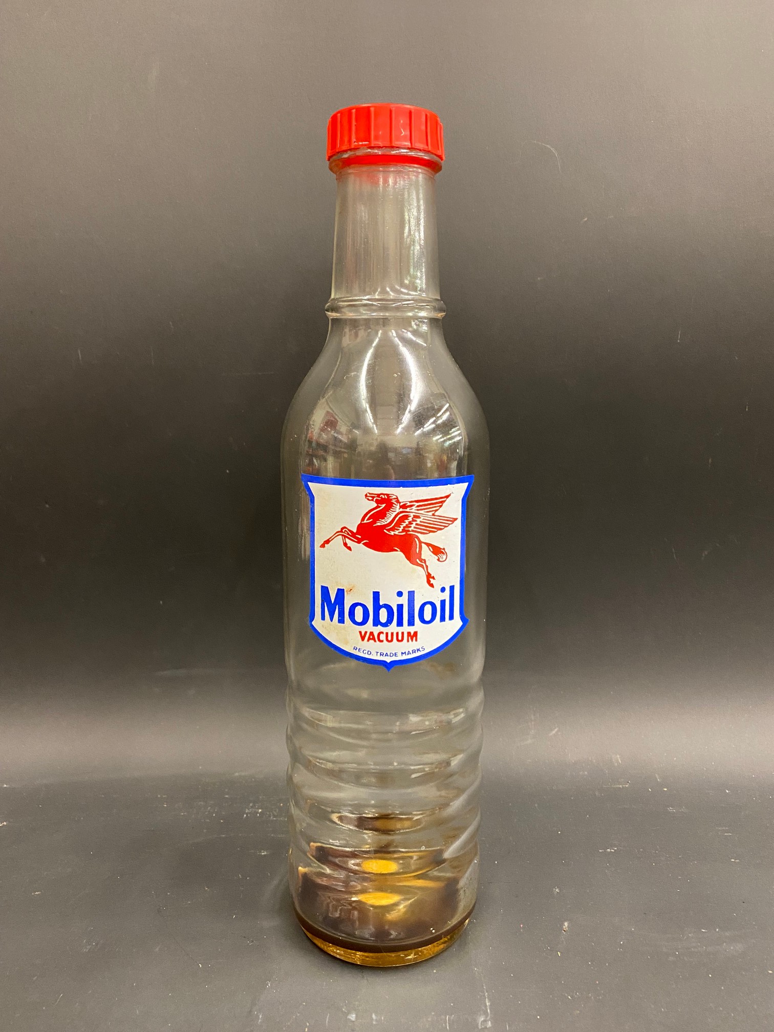 A Mobiloil glass quart oil bottle, unusually with the additional word 'Vacuum' to the label.