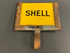 A small yellow Shell enamel petrol pump brand indicator, in holder.