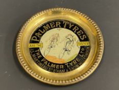 A rarely seen Palmer Tyres brass and glass inset dish, with central image of two cyclists racing,