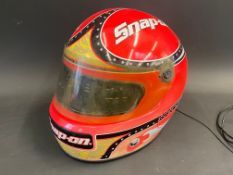 A radio in the shape of a motorcycle helmet with Snap On advertising.