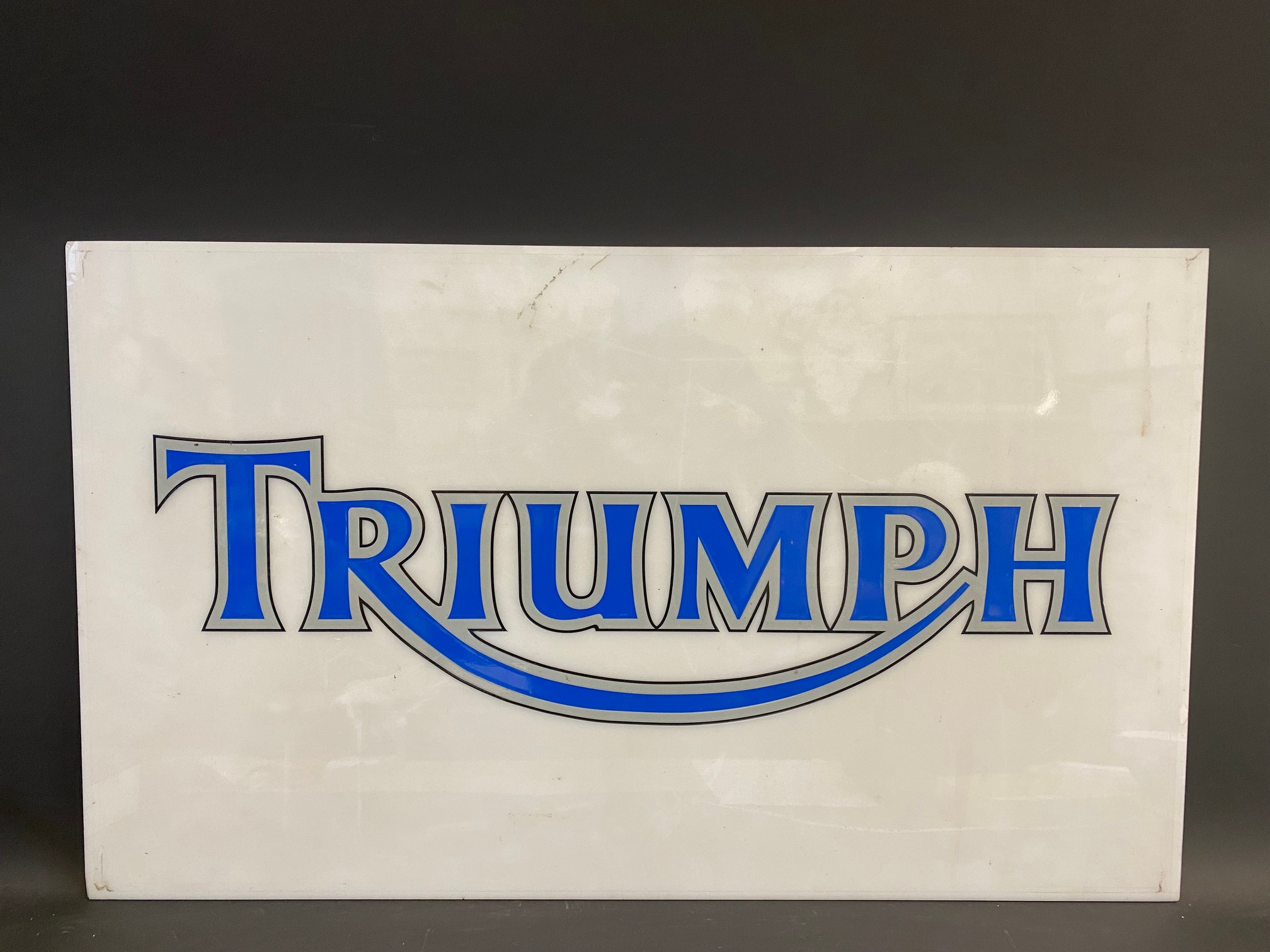 A rectangular Triumph plastic advertising sign, probably the front panel from a lightbox, 39 x 23".