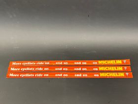 Three narrow Michelin tin advertising shelf strips 'More cyclists ride on...and on...'.