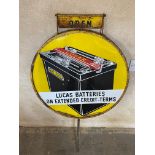 A Lucas Batteries circular enamel sign, in a garage forecourt spinning frame, with open/closed