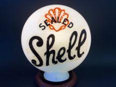 A reproduction petrol pump globe with Shell decal to one side and Pratts to the other.