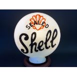 A reproduction petrol pump globe with Shell decal to one side and Pratts to the other.