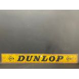 A narrow metal sign advertising Dunlop, possibly from a rack, 48 x 6".