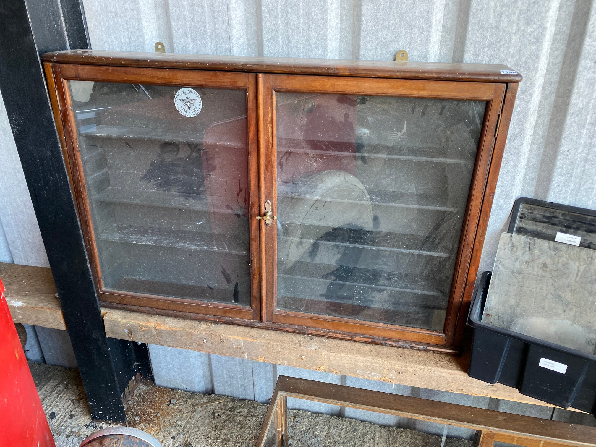 An Edwardian mahogany and stained pine wall mounted two door display cabinet, with adjustable