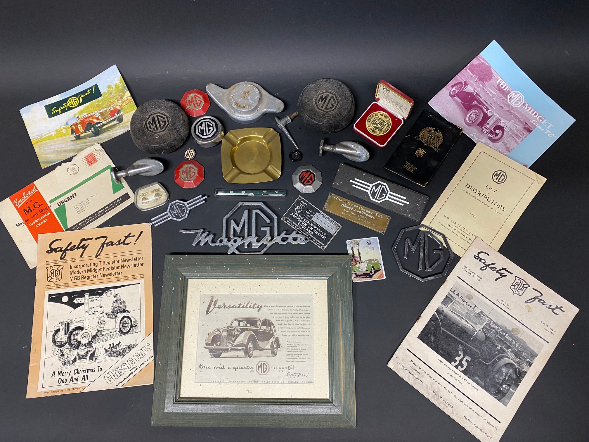 A selection of MG related promotional items, car insignia, branded car parts etc.
