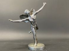 A chrome plated accessory mascot in the form of a scantily clad winged lady standing on one leg.
