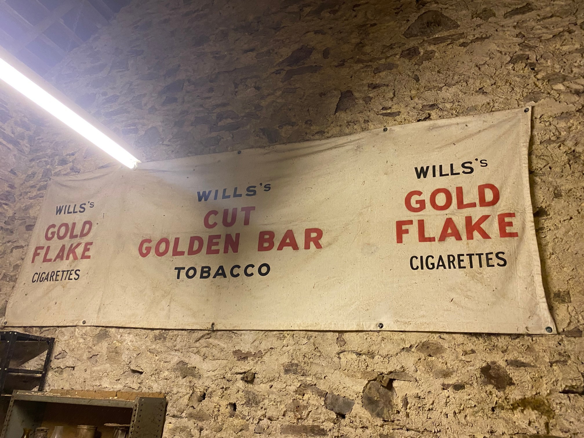 A large advertising banner for Wills's Cigarettes and Tobacco.