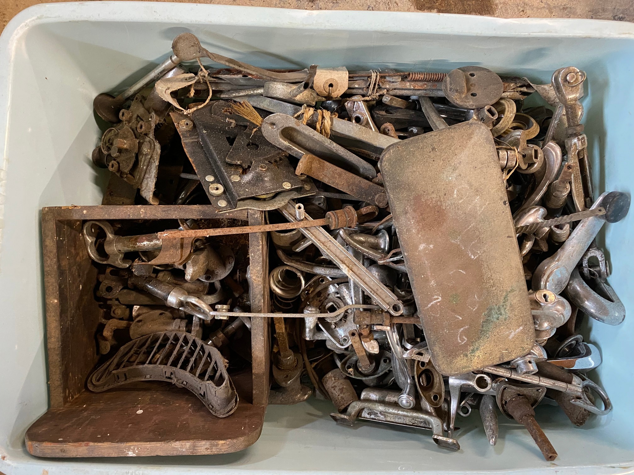 A tray of assorted car parts, chrome handles and bonnet catches included.