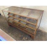 An Edwardian light oak shop counter habidashery type cabinet with pull out drawers to the rear,