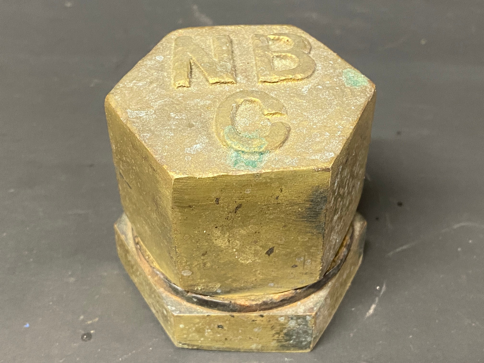 An NBC hexagonal brass bulk tank dipstick cover.