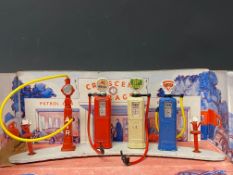 A Crescent Toys set of die-cast petrol pumps, air tower and oil pumps, on a curved base.